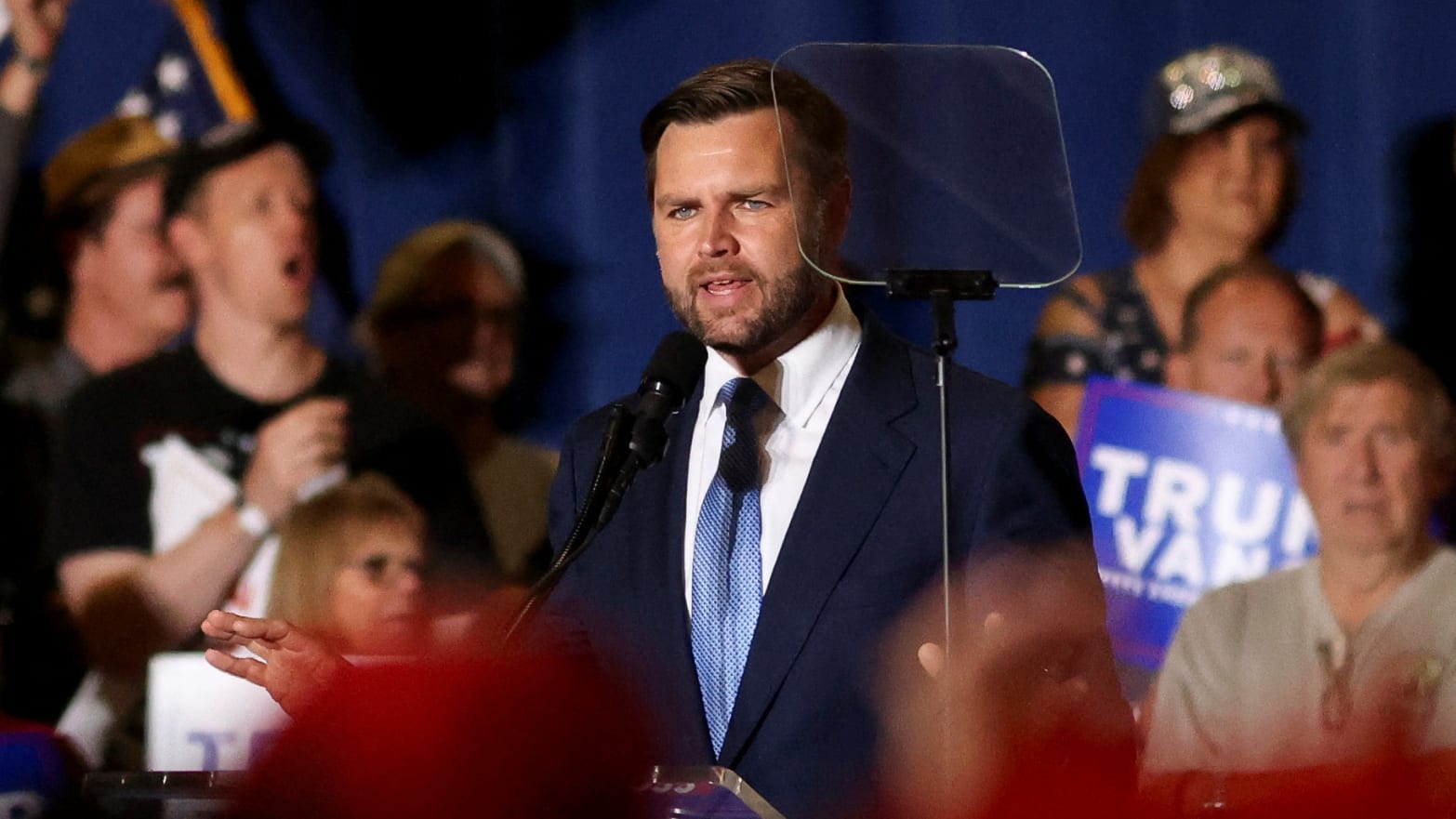 J.D. Vance looks at a teleprompter while speaking on stage.