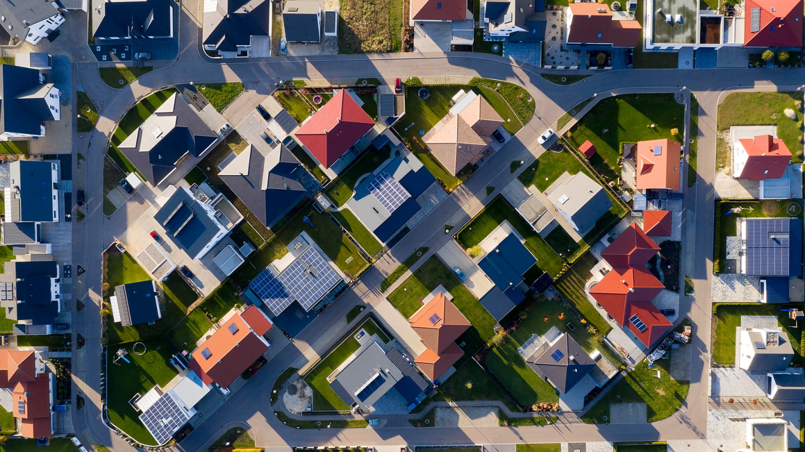 An aerial view of a neighborhood – the organized houses and roads make patterns in the landscape.