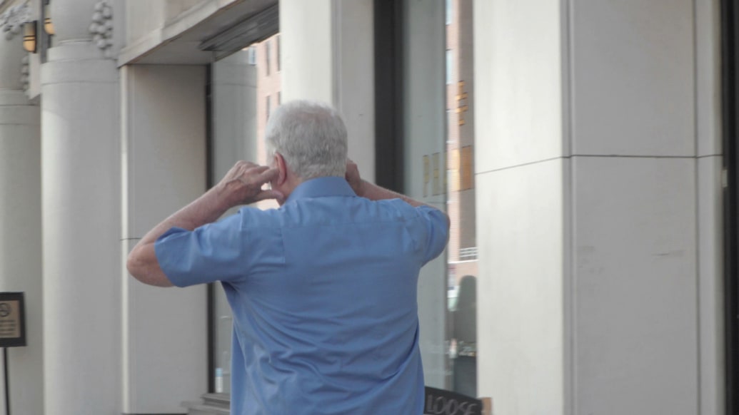 A still from episode two of How to With John Wilson showing an older man covering his ears.