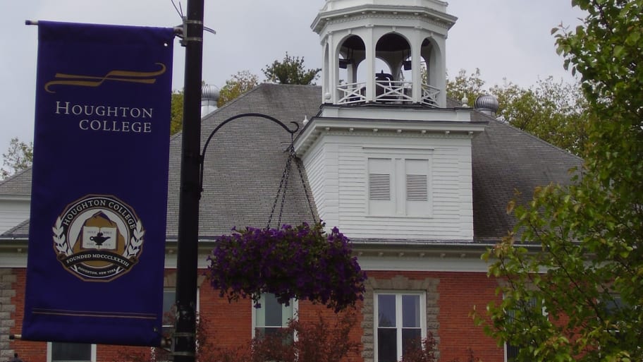 Houghton College’s oldest building, Fancher Hall, seen with a banner displaying the school seal.