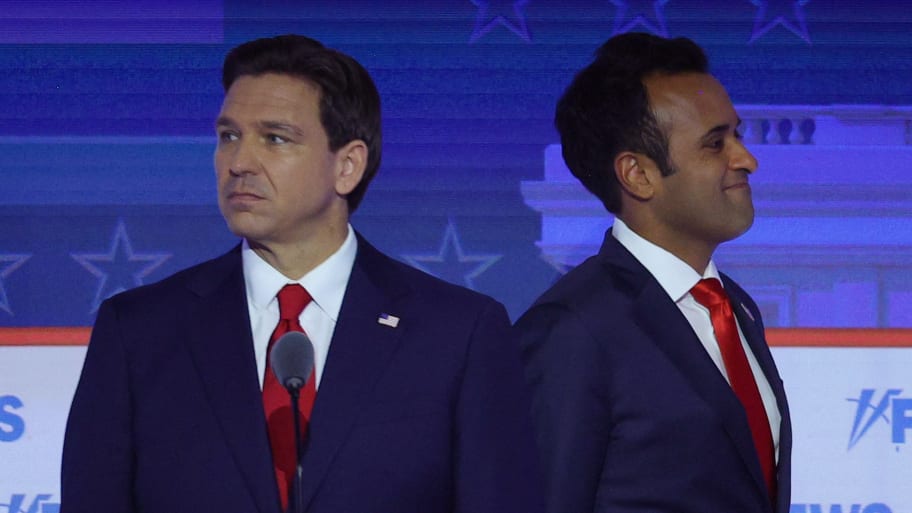 Former biotech executive Vivek Ramaswamy passes behind Florida Governor Ron DeSantis during a break at the first Republican candidates' debate of the 2024 U.S. presidential campaign in Milwaukee, Wisconsin.