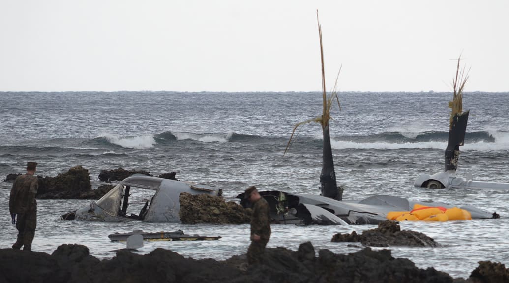 The wreckage of a US Marine MV-22 Osprey tilt-rotor aircraft is seen as the tide recedes on the coast of Nago, Japan's southern island of Okinawa on December 14, 2016, after it crash landed in shallow waters late December 13.