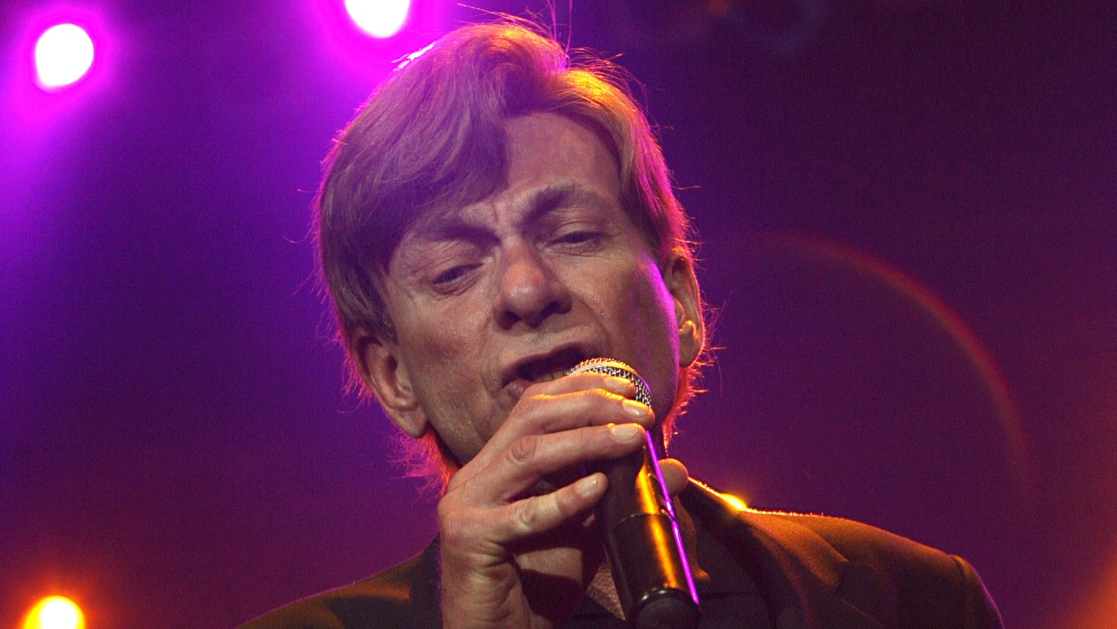 Bobby Caldwell performs in a neon-lit room