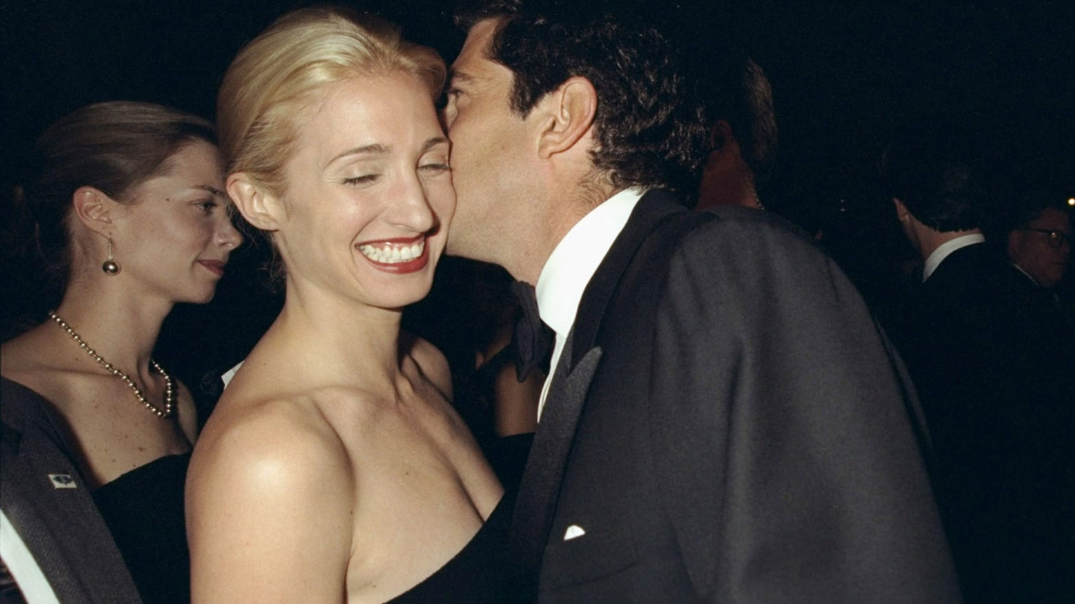 John F. Kennedy Jr. whispers to Carolyn Bessette-Kennedy as they attend a gala dinner in New York on October 5, 1998.