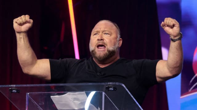 Alex Jones pumps the air with both fists