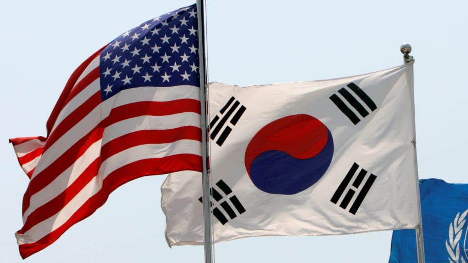 Flags of the U.S., South Korea, and the United Nations (L to R) flap in the wind at the Korean War Memorial Museum in Seoul, May 26, 2009. 
