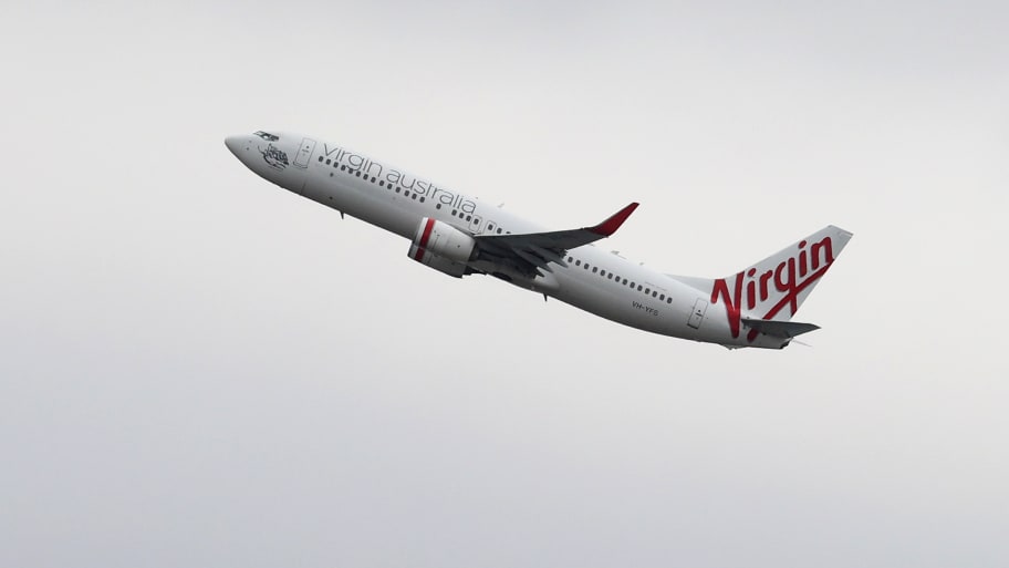 A Virgin Australia flight turned back to Perth after an allegedly naked man knocked over a crew member. 