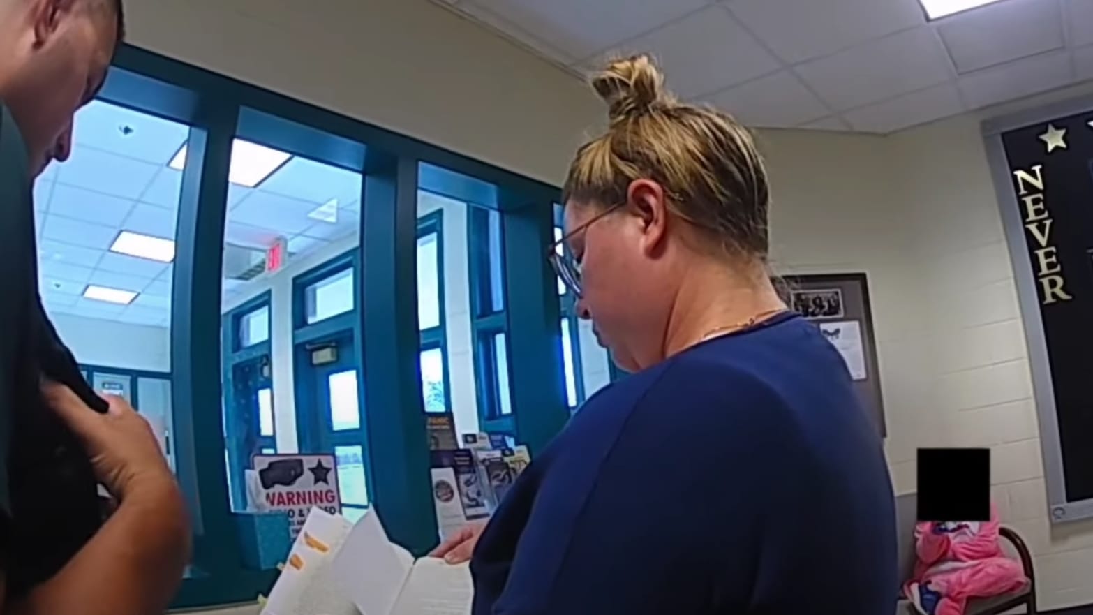 A Moms for Liberty member shows cops a book.