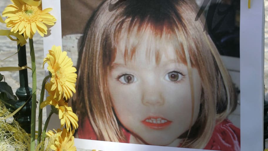 Poster of Madeleine McCann is surrounded by flowers and hope bows in the Portuguese beach resort of Lagos, May 12, 2007. 