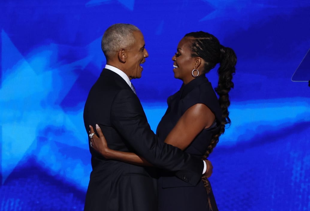 Former U.S. first lady Michelle Obama greets her husband, former U.S. President Barack Obama, on stage before his speech during Day 2 of the Democratic National Convention (DNC) in Chicago, Illinois, U.S., August 20, 2024.