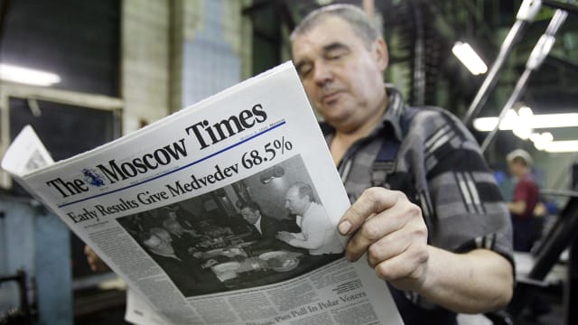 Man reads a copy of The Moscow Times newspaper