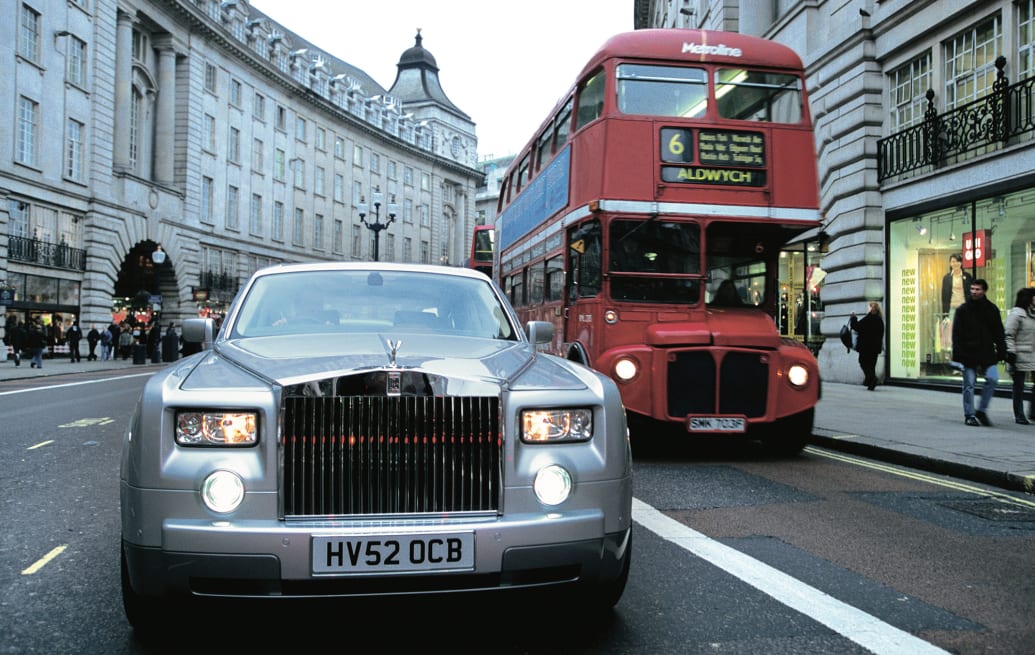 Rolls-Royce Phantom driving past a red London bus.