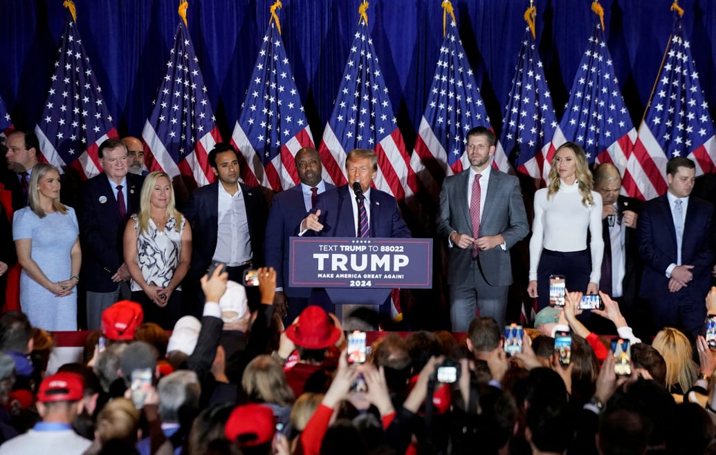 Rep. Marjorie Taylor Greene, former Republican presidential candidates Vivek Ramaswamy and Sen. Tim Scott, along with Eric Trump and his wife Lara, flank former President and Republican presidential candidate Donald Trump.