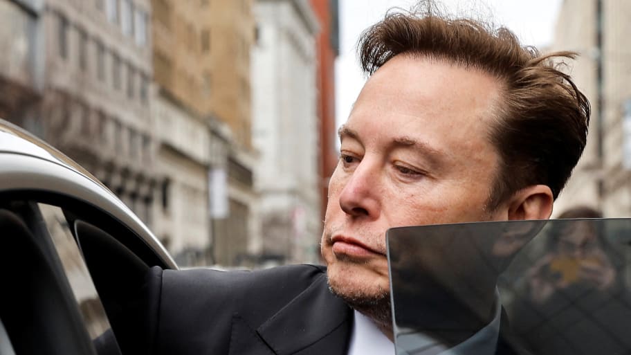 Elon Musk steps into a car.