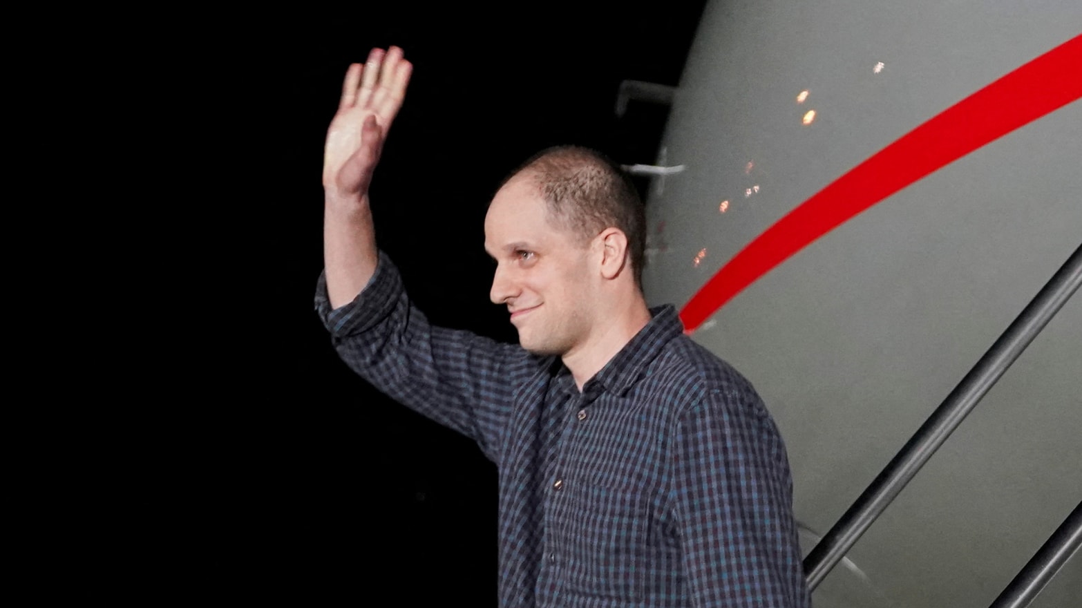 Evan Gershkovich waves on the tarmac after returning home after more than a year in lock-up