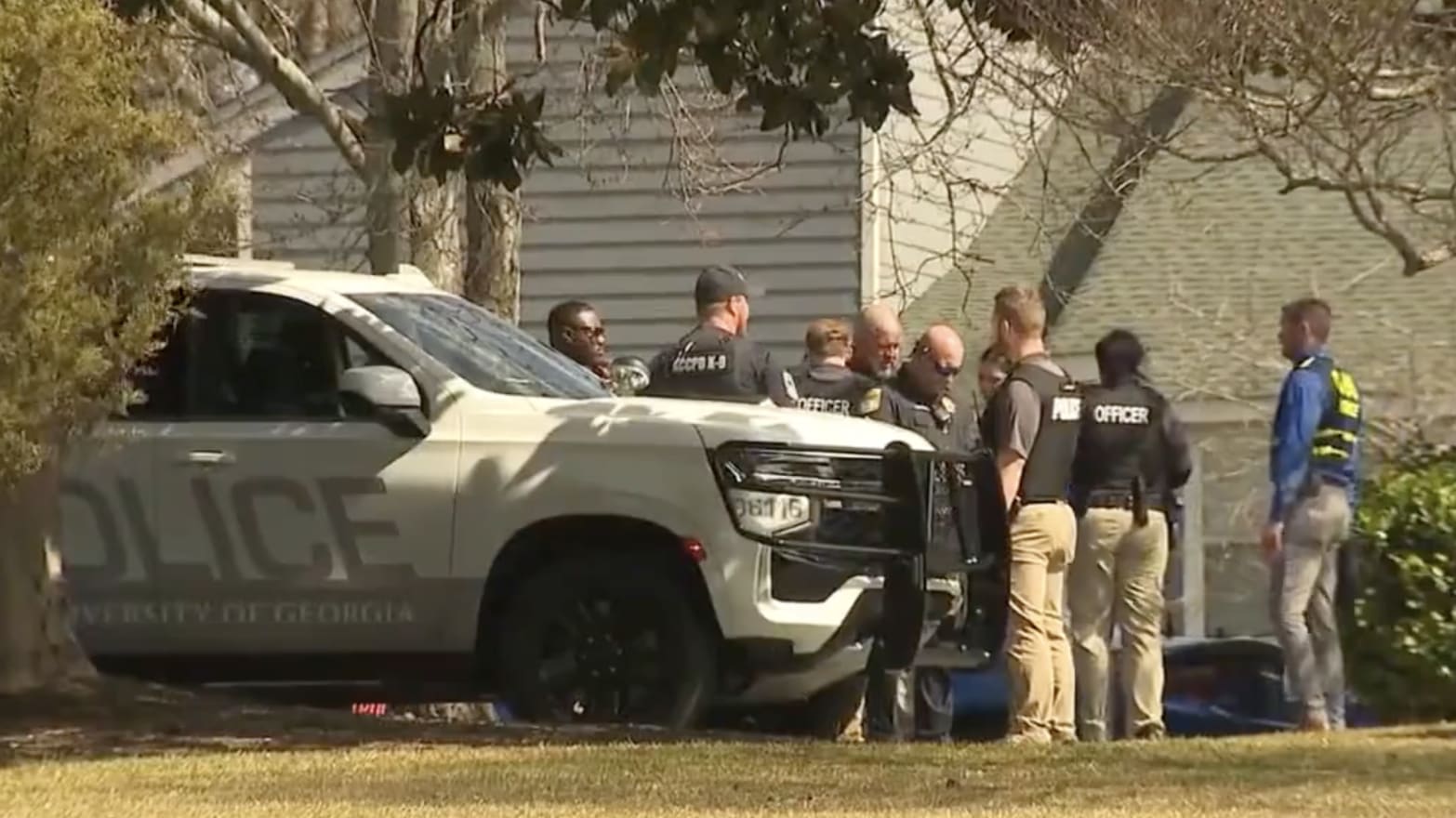 Police are seen outside an apartment that was searched in connection with the killing of a 22-year-old nursing student. 