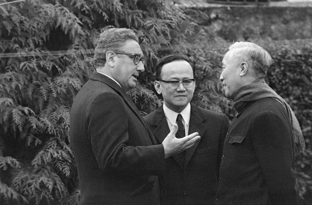An interpreter stands between White House advisor Henry Kissinger and Hanoi's senior representative Le Duc Tho.