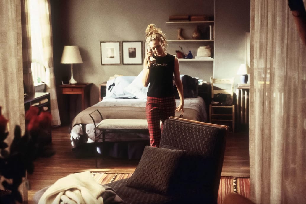 A still of Carrie Bradshaw standing in her Upper East Side apartment in Sex and The City.