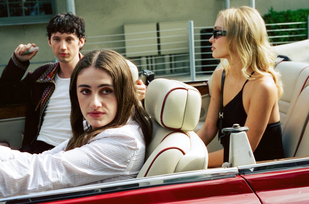 Troye Sivan, Rachel Sennott, and Lily-Rose Depp sit in a convertible car during a scene from The Idol.
