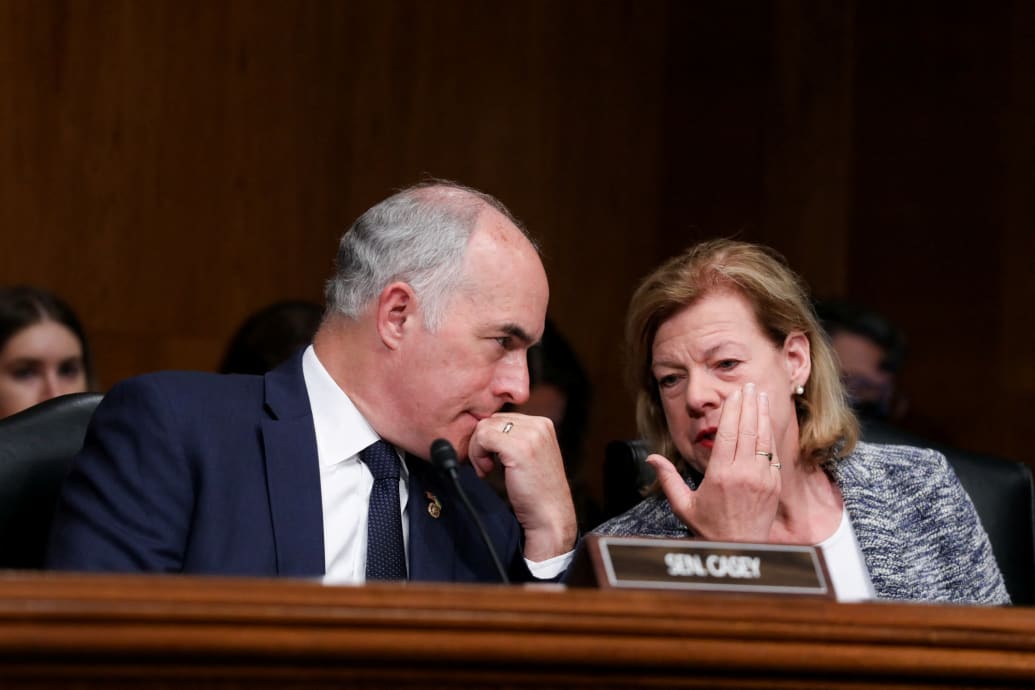 Sen. Bob Casey speaks to Sen. Tammy Baldwin during a Senate Health, Education, Labor and Pensions Committee hearing.