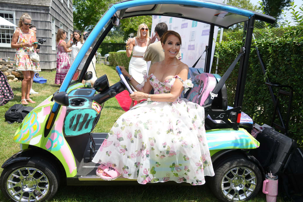 A photo of Jill Zarin posing in a golf cart at her Luxury Luncheon.