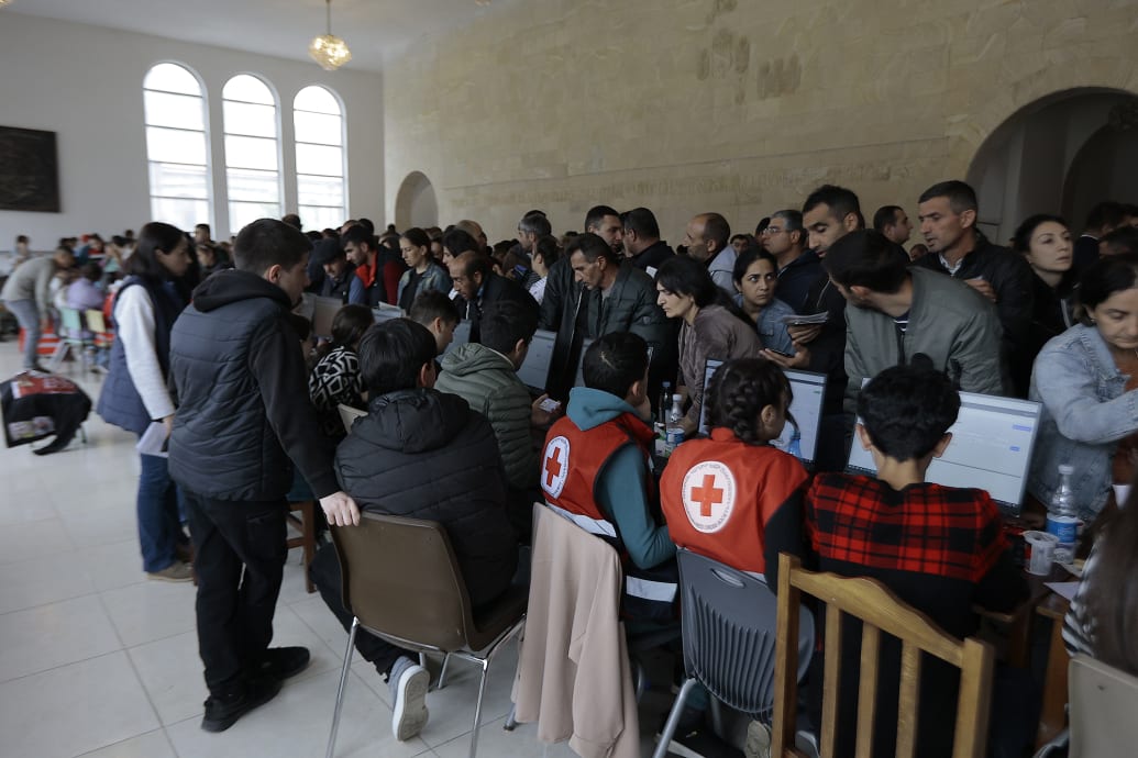 Red Cross workers help refugees at Goris theater.