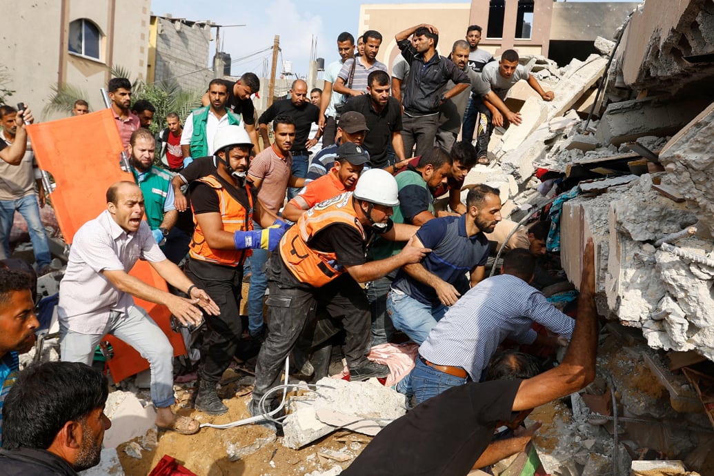Palestinians search for casualties under the rubble of a house destroyed in Israeli strikes in Khan Younis, in the southern Gaza Strip, Oct. 8, 2023.