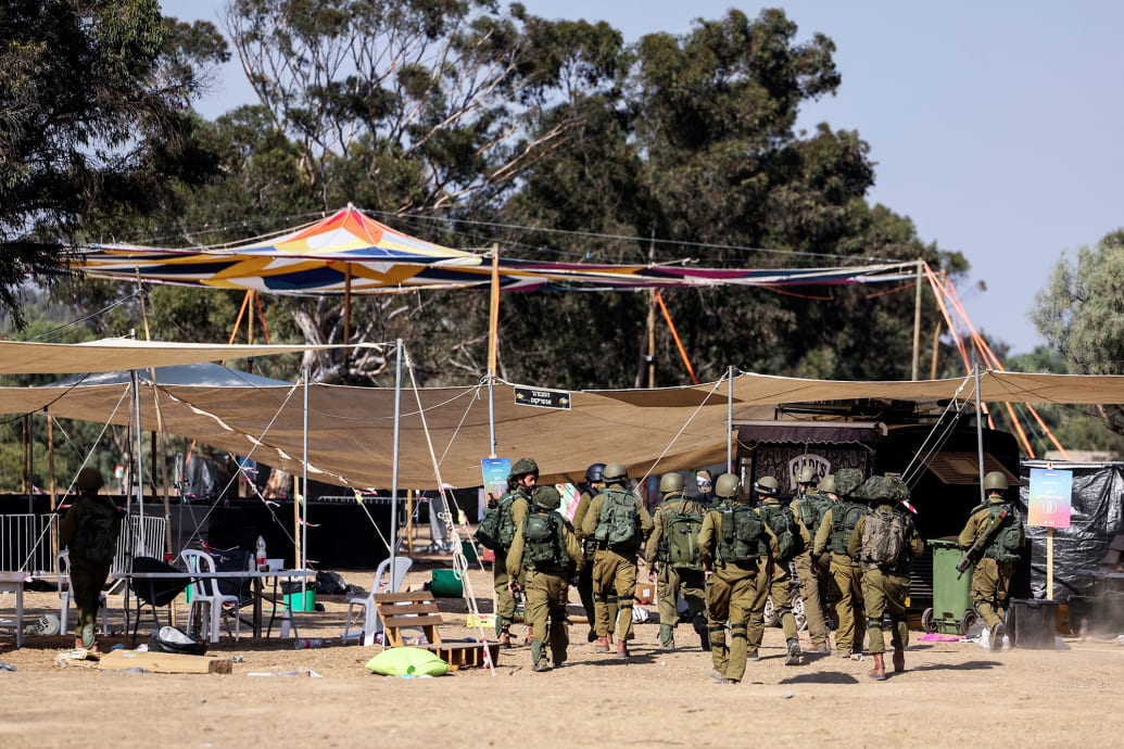 Israeli soldiers walk through the site of an attack on the Nova Festival by Hamas.