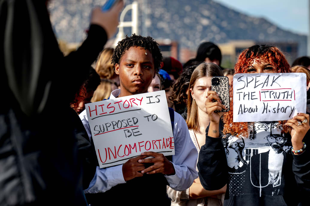 Great Oak High School students hold signs during a protest of the districts ban of critical race theory curriculum at Patricia H. Birdsall Sports Park in Temecula.