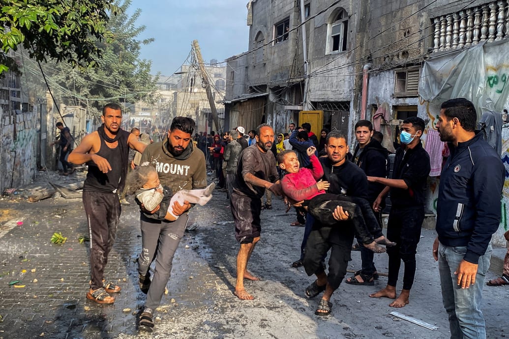 Palestinians carry wounded children following an Israeli strike on a house in Rafah.