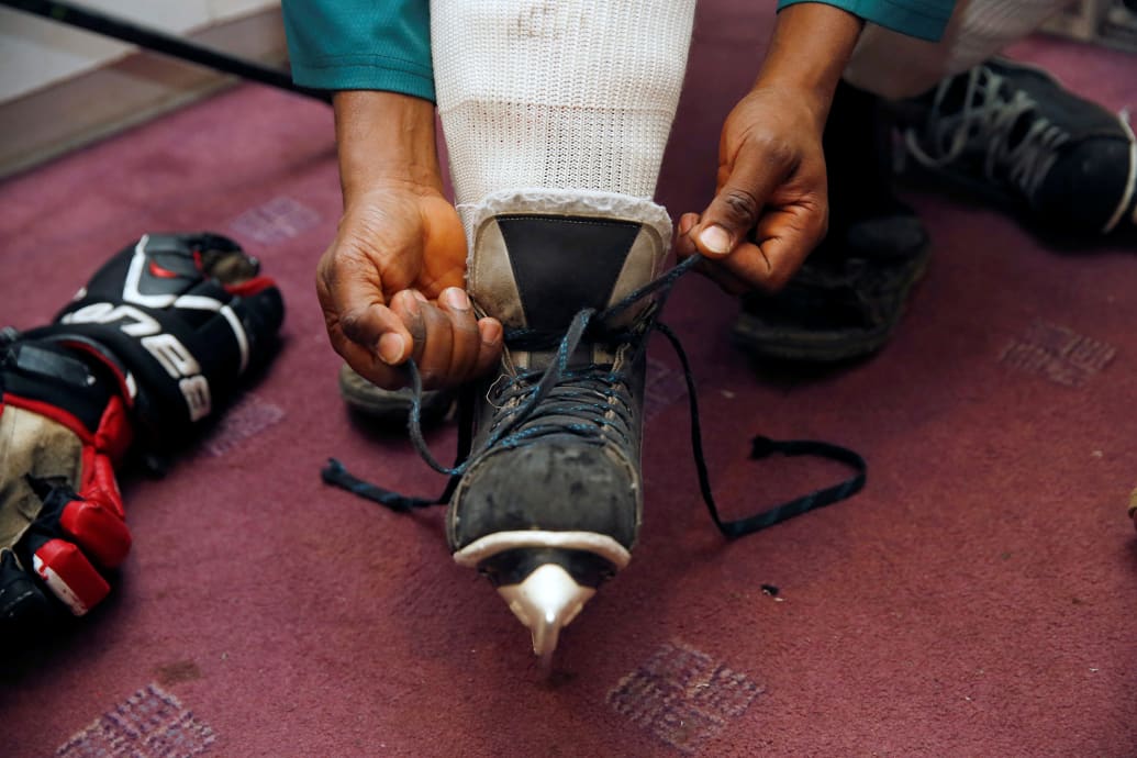 A member of Kenya's ice hockey team puts on his skates before a practice session.