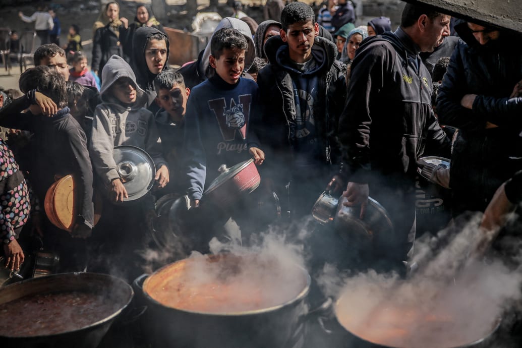 Palestinians gather to collect aid food in Beit Lahia, in the northern Gaza Strip, on Feb. 26, 2024.
