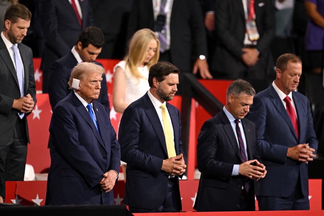 Donald Trump (L) and US Senator from Ohio and 2024 Republican vice presidential candidate J.D. Vance (C) stand in prayer during the second day of the 2024 Republican National Convention at the Fiserv Forum in Milwaukee, Wisconsin, July 16, 2024. 