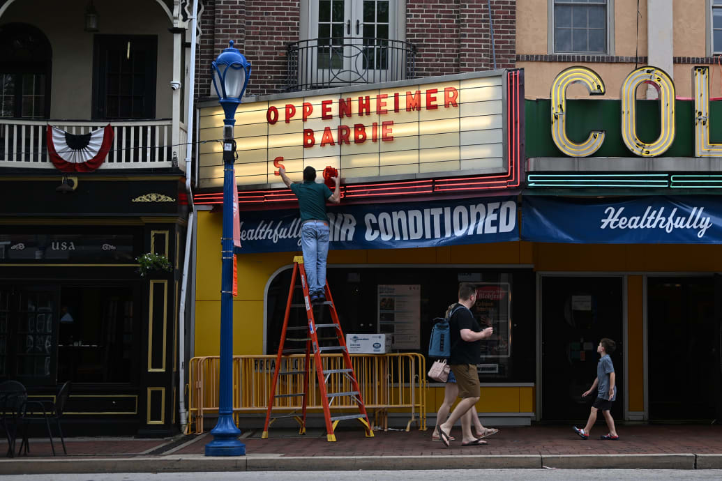 A theater employee adds the movies Oppenheimer and Barbie to the Colonial Theater’s marquee in Pennsylvania.