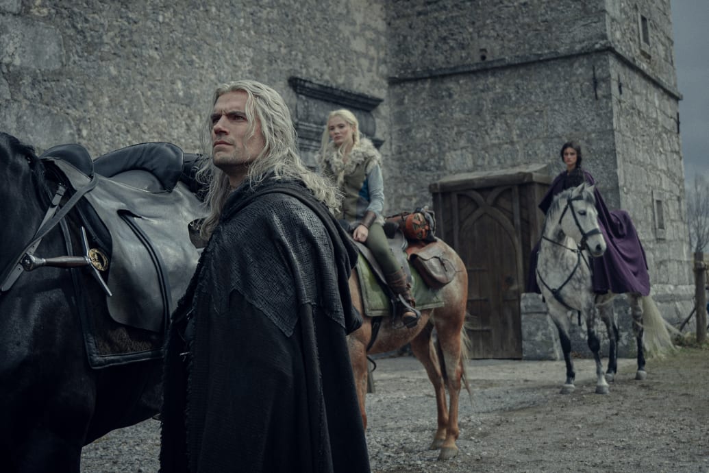 A production still of Henry Cavill, Freya Allan, and Anya Chalotra in the third season of The Witcher.