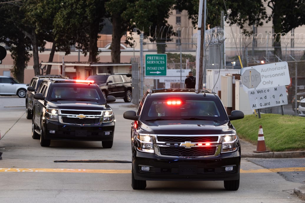 The SUV carrying former President Donald Trump exits the Fulton County Jail.