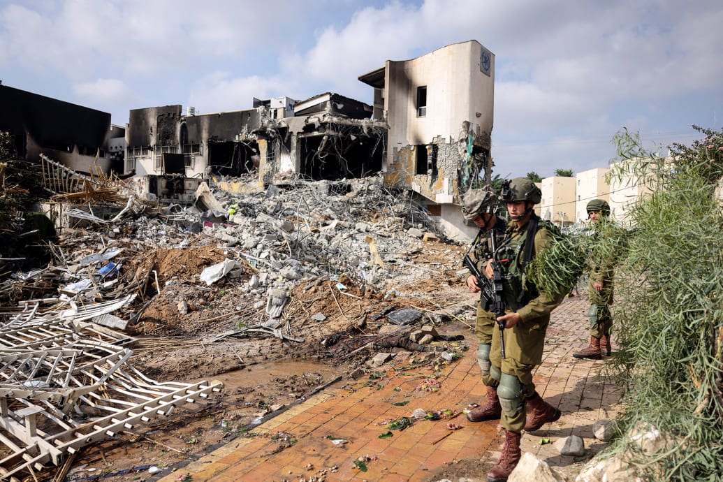 Israeli soldiers patrol outside a police station which was the site of a battle following a mass infiltration by Hamas.