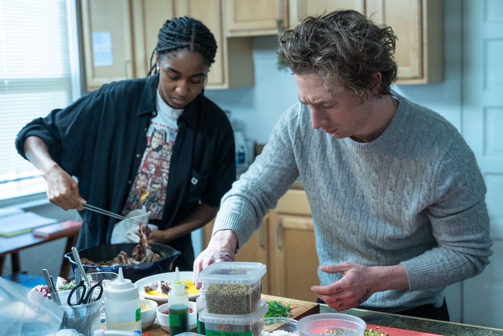 Ayo Ebebiri y Jeremy Allen White cocinan en una cocina durante una escena de The Bear Season 2.