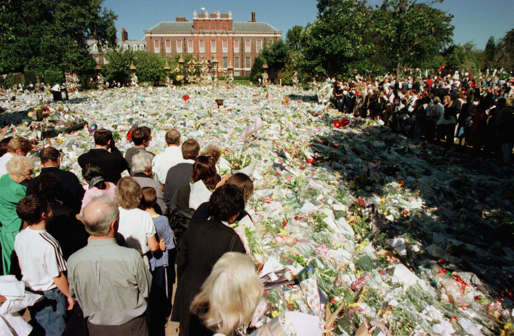 Crowds gaze at a carpet of flowers placed by mourners outside Kensington Palace September 4, 1997, two days prior to Princess Diana's funeral.