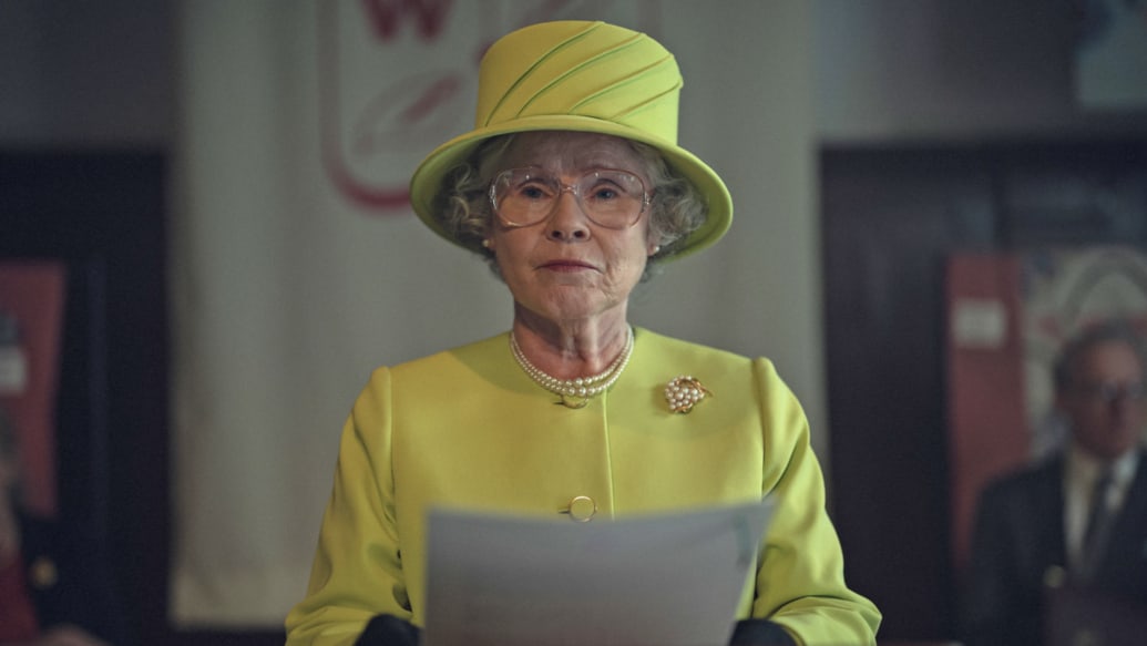 Imelda Staunton as the Queen holds papers and stands in a still from 'The Crown
