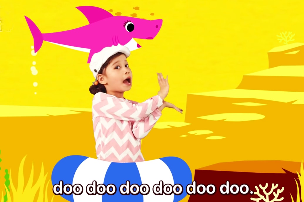 girl dancing with pink shark swimming in background of baby shark music video human brain neuroscience music why is it stuck in my head catchy earworm science video youtube billboard top hot 100 children kids song
