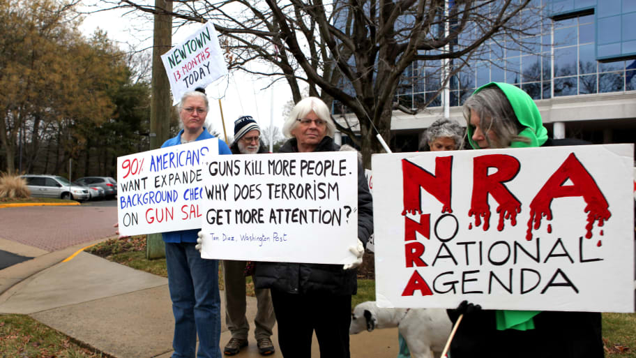 A group of people protest against individual armament outside the National Rifle Association (NRA) building in Fairfax, Virginia.
