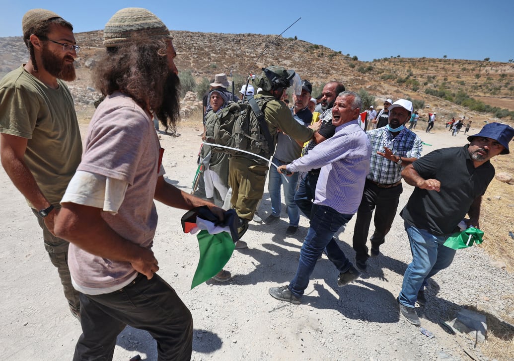 Israeli settlers fight with Palestinian protesters during a demonstration against settlement expansion, in the village of al-Mughayer.