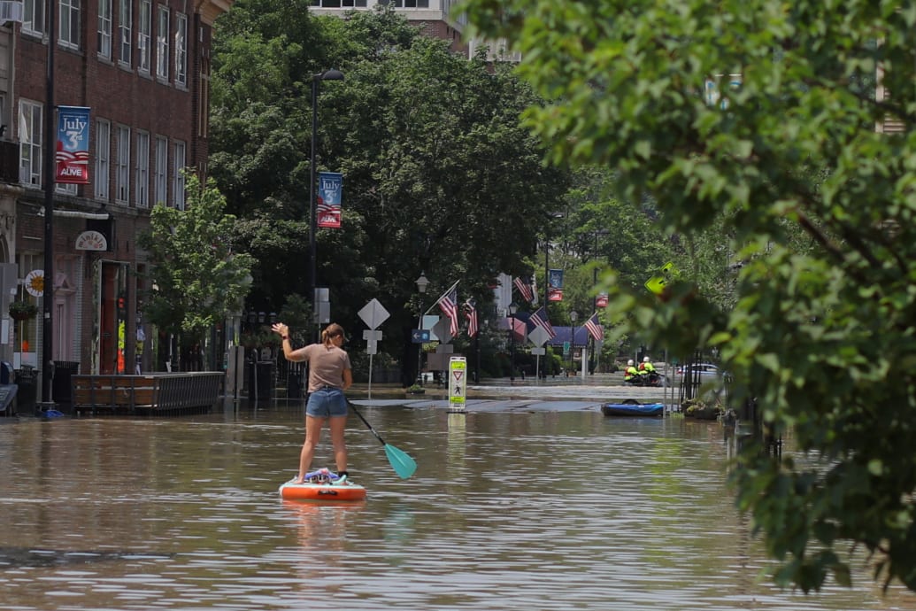 A person rows a paddle board in a flooded area in Montpelier, Vermont, U.S. July 11, 2023.