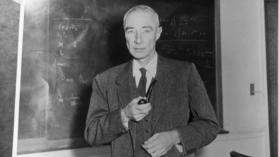 Robert Oppenheimer, American physicist, Director of the Manhattan project, standing before blackboard, holding pipe