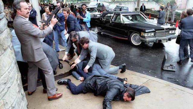 White House Press Secretary James Brady and District of Columbia police officer Thomas Delahanty lie wounded on the ground after John Hinckley Jr. fired six shots at President Ronald Reagan