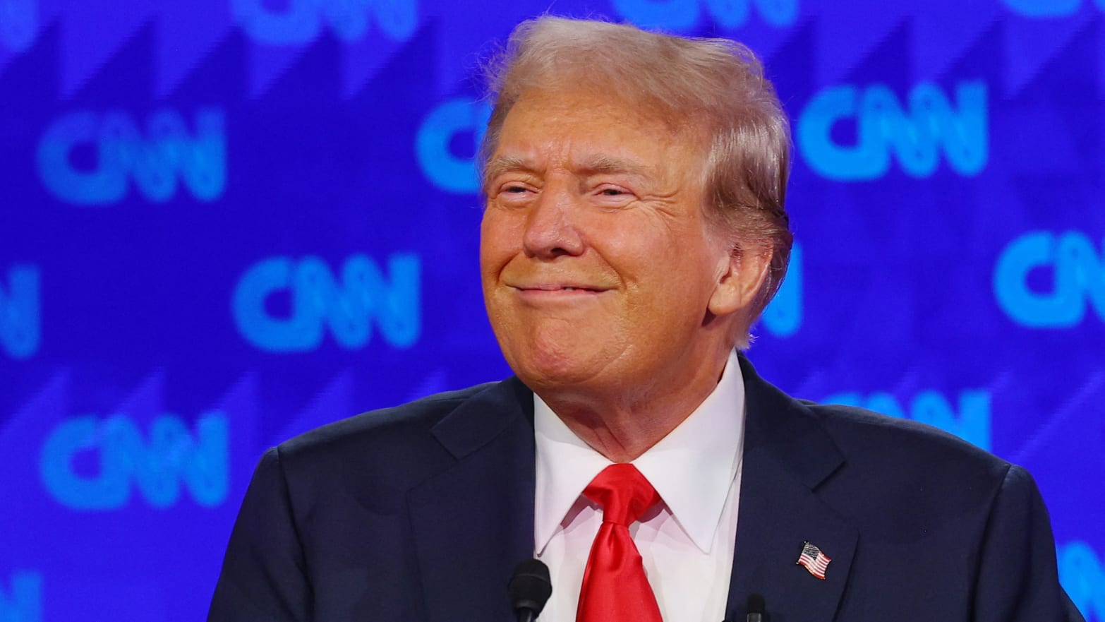 Donald Trump smirks on stage during a debate against Joe Biden.