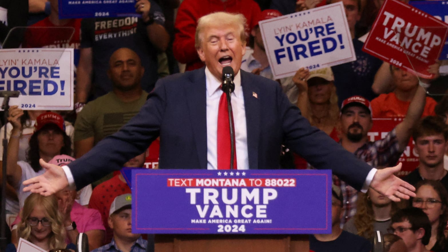 Donald Trump hands outstretched behind a lectern marked Trump-Vance