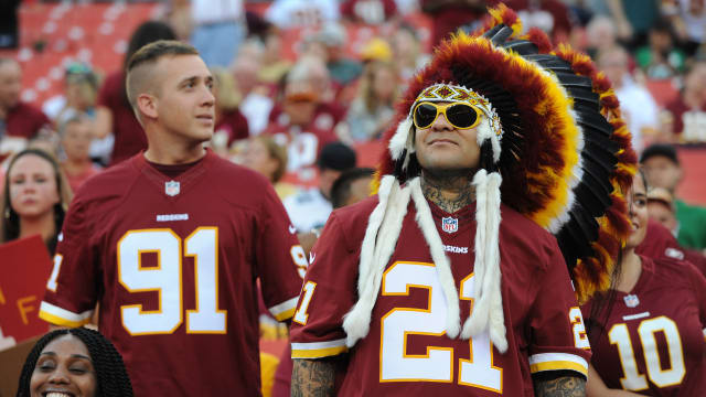 A fan at a Washington Redskins game wears a traditional feather headdress.