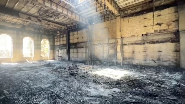 An interior view of Derbent synagogue following an attack with a pool of light inside the ruins.